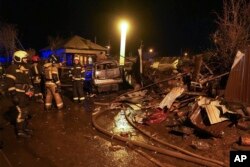 Firefighters work at the scene after a warplane crashed into a residential area in Irkutsk, Russia, Oct. 23, 2022.