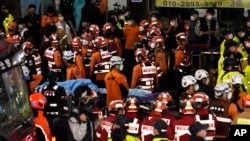 Para petugas SAR, damkar, dan polis membantu evakuasi korban desak-desakan saat perayaan Halloween di Seoul, Korea Selatan, Minggu, 30 Oktober 2022. (Foto: Lee Jin-man/AP Photo)