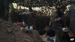 Seorang tentara Ukraina tampak memeriksa parit yang digali oleh tentara Rusia di wilayah Kherson, pada 12 Oktober 2022. (Foto: AP/Leo Correa)