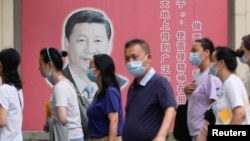上海民众走过街头树立的一面中国领导人习近平的宣传画。（2022年8月31日）