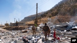 Members of exiled Komala Party inspect aftermath of bombing in the village of Zrgoiz, near Sulaimaniyah, Iraq, where the bases of several Iranian opposition groups are located, Sept. 28, 2022. 
