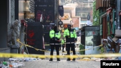 Police stand guard at the scene where a stampede during Halloween festivities killed and injured many people at the popular Itaewon district in Seoul, South Korea, Oct. 30, 2022. 