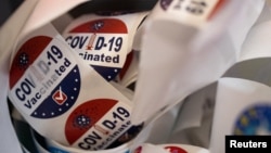 FILE - Patients receive stickers after receiving the coronavirus disease booster vaccine at Skippack Pharmacy in Schwenksville, Pa., Sept. 8, 2022. 