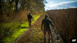 Ukrainian territorial defense deminers search for mines near Hrakove village, Ukraine, Oct. 13, 2022. 