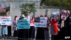 Afghan women hold placards as they take part in a protest in front of the Iranian embassy in Kabul, Sept. 29, 2022. 