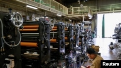 FILE - A worker checks machinery at a factory in Higashiosaka, Japan June 23, 2022. 