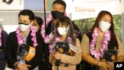 A group of foreign travelers hold souvenirs after arriving at Taoyuan International Airport in Taoyuan, Northern Taiwan, Oct. 13, 2022. 