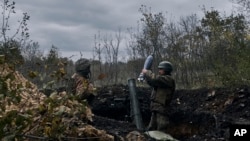 Ukrainian soldiers fire the Russian positions with the mortar in Bakhmut, Donetsk region, Ukraine, Oct. 21, 2022.