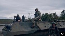 Ukrainian servicepeople pose for a photo with their armored vehicle near Bakhmut, Donetsk region, Ukraine, Oct. 22, 2022.