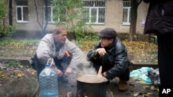 Residents cook outdoors in Bakhmut, the site of the heaviest battle against the Russian troops in the Donetsk region, Ukraine, Oct. 26, 2022. Ukrainian President Volodymyr Zelenskyy says Ukrainians need to be conscious about energy consumption.