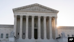 The sun rises behind the U.S. Supreme Court, Oct. 11, 2022, in Washington. 