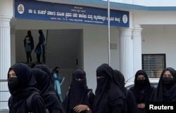 FILE - Hijab-wearing Muslim students walk in the premises of Government First Grade College and Centre for P.G Studies, after the recent hijab ban in Udupi town in the southern state of Karnataka, India, Feb. 17, 2022.