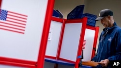 FILE - McArthur Myers fills out his ballot at an early voting location in Alexandria, Va., Sept. 26, 2022.