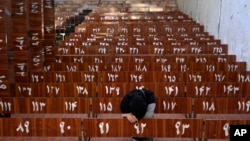A 19-year old Hazara Afghan girl sits and cries on the same bench she was sitting on the previous day, when a suicide bomber struck a Hazara education center in Kabul on September 30, 2022. (Ebrahim Noroozi/AP)