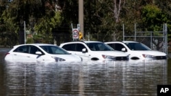 Tiga mobil terjebak dalam banjir di Shepparton, Australia, Senin, 17 Oktober 2022. Sekitar 34.000 rumah dapat terendam atau terisolasi di negara bagian Victoria saat keadaan darurat banjir berlanjut di bagian tenggara Australia. (Diego Fedele/AAP via AP)