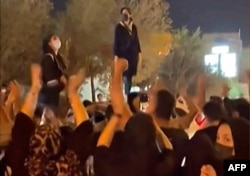 Iranian women protest following the death of 22-year-old Kurdish woman Mahsa Amini, in the central city of Yazd, Sept. 26, 2022, in this screen grab taken from UGC video.
