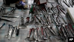 Tools used for "papel picado", the traditional manufacture of tissue paper cut-out decorations, long used in altars for the Day of the Dead, lay on a table in a workshop in Xochimilco, a borough of Mexico City, Oct. 27, 2022.