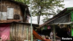 A woman hangs clothes to dry on the roof of her flooded home following heavy rains brought by tropical storm Nalgae, in Imus, Cavite province, Philippines, Oct. 30, 2022.