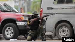 FILE - A soldier positions himself outside the military base near the presidential palace in Port-au-Prince, Haiti, after gangs waged intense gun battles, shuttering main avenues and a municipal market in the downtown area, July 27, 2022. 
