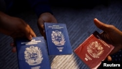 ARCHIVO - Migrantes venezolanos muestran sus pasaportes en Ciudad Juárez, México, en octubre 2022.