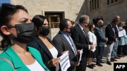 Journalists' associations and unions' representatives protest wearing protective black masks covering their nose and mouth against a draft law criminalizing 'disinformation' as an attempt of censorship by the Turkish government in Ankara, on October 4, 2022. 