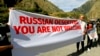 FILE - Activists hold an anti-Russian banner during an action organized by political party Droa near the border crossing at Verkhny Lars between Georgia and Russia in Georgia, Sept. 28, 2022. Some Georgians hace voiced concerns about the exodus of Russians into their country.
