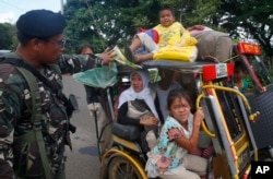 Residents fleeing the besieged city of Marawi are questioned at a checkpoint by government soldiers, May 26, 2017.