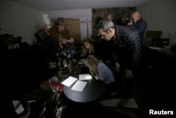 FILE - News media look at documents left inside the home of suspects Syed Rizwan Farook and Tashfeen Malik in Redlands, California, following Wednesday's attacks, Dec. 4, 2015.