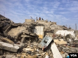 FILE - Families sift through the destruction as many homes, hospitals and other buildings were destroyed by Islamic State or in the fighting over the past four months in Mosul, Iraq, Jan. 30, 2017. (H. Murdock/VOA)