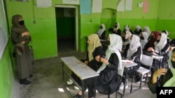 FILE - Girls attend a class at their school in Kabul, March 23, 2022. The Taliban prohibition on girls' education shows ultra-conservatives retain control of the Islamist group and exposes a power struggle putting at risk crucial aid for Afghanistan's desperate population.