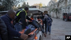 Palestinians evacuate a wounded man during clashes with Israeli security forces in Jerusalem's Old City on April 15, 2022