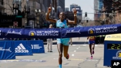 Peres Jepchirchir of Kenya crosses the finish line to win the women's division of the Boston Marathon, April 18, 2022.