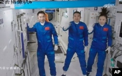 FILE - In this photo released by Xinhua News Agency on Oct. 16, 2021, shows three Chinese astronauts, from left, Ye Guangfu, Zhai Zhigang and Wang Yaping.