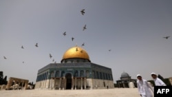Palestinian Muslims walk in front of the Dome of Rock mosque at the Al-Aqsa mosque compound in Jerusalem's Old City, Apr. 17, 2022. 