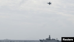 FILE - An Indonesian Airforce F-16 Jet Fighter flies over Indonesian navy warship during an operation in Natuna, near the South China Sea, Indonesia, Jan. 10, 2020 in this photo taken by Antara Foto.