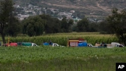 FILE - Gasoline thieves wait in line to steal gas from an illegal tap into a state-owned pipeline, in the middle of a cornfield in San Bartolome Hueyapan, Tepeaca, Mexico, July 11, 2017.