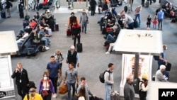 美国科罗拉多州丹佛机场的旅客有人戴口罩，有人已经不戴口罩了。（2022年4月19日）