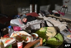 An elderly woman sleeps on the floor as residents of a building, partially destroyed after shelling, live in its basement on the northern outskirts of Kharkiv, Ukraine, April 5, 2022.