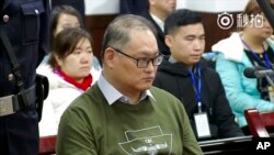 Aktivis hak asasi manusia Taiwan Lee Ming-che duduk selama sesi pengadilan di Pengadilan Rakyat Menengah Yueyang di Yueyang di Provinsi Hunan, China tengah. (Foto: via AP video)