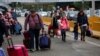 Ukrainians who fled to Mexico amid Russia's invasion of their homeland, walk with their belongings to cross the San Ysidro Land Port of Entry of the U.S.-Mexico border, in Tijuana, Mexico, April 2, 2022