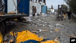 A body is covered by a tarp following a Russian bombing of a factory in Kramatorsk in eastern Ukraine, on April 19, 2022. 