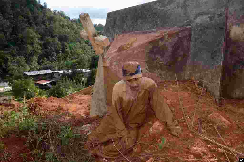 Lazaro Martinez sits in the mud while continuing to search for his wife and two children in the town of La Pintada, Mexico, Nov. 1, 2013. Villagers are demanding that the government continue the recovery of bodies after a mudslide buried dozens after Tropical Storm Manuel more than a month ago.