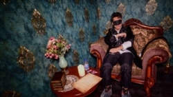 FILE - This photo taken Aug. 13, 2020, shows a player taking part in a live action role-playing murder mystery game, "The Haunted Mansion," at a studio in Shanghai. Friends sometimes use phones to help them with clues but they are mainly reading from scripts and debating who could be the killer on the loose.