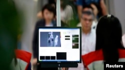 Para penumpang pesawat disaring saat tiba di Bandar Udara Internasional Yangon, Myanmar (20/8). (Reuters/Soe Zeya Tun)