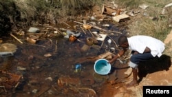 FILE - Residents fetch water from unprotected sources in Harare, Zimbabwe, July 28, 2012. The country is now dealing with another outbreak of typhoid fever.