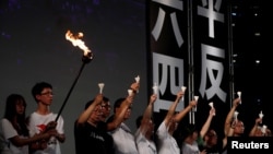 FILE - Pro-democracy activists raise up candles during a candlelight vigil to mark the 30th anniversary of the crackdown of China's pro-democracy movement at Beijing's Tiananmen Square in 1989, at Victoria Park in Hong Kong, June 4, 2019.