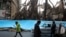 People walk past buildings that were burned during recent protests, in Shahriar, Iran, some 40 kilometers (25 miles) southwest of the capital, Tehran, Nov. 20, 2019. 