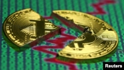FILE - Illustration of the Bitcoin virtual currency, placed on a monitor that displays stock graph and binary codes, are seen in this illustration picture, Dec. 21, 2017. 