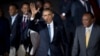 U.S. President Barack Obama waves after being greeted by Kenya's President Uhuru Kenyatta, right, on his arrival at the Jomo Kenyatta International Airport in Nairobi, Kenya, July 24, 2015. 