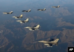 Four South Korean Air Force F-35 fighter jets, left top, and four US Air Force F-16 fighter jets fly over South Korea during a joint air drill in South Korea, Nov. 18, 2022. Photo provided by South Korean Defense Ministry.